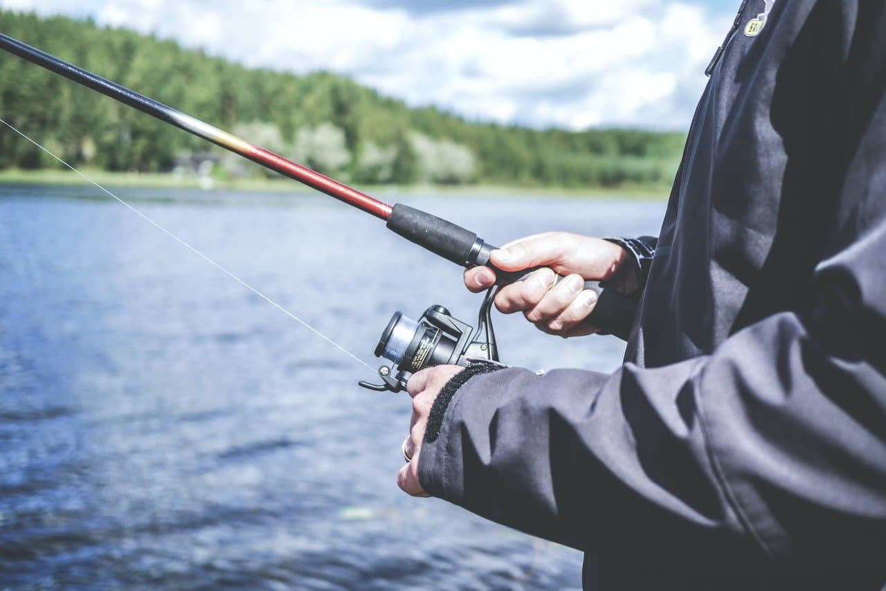 image of man holding his fishing rod and reel