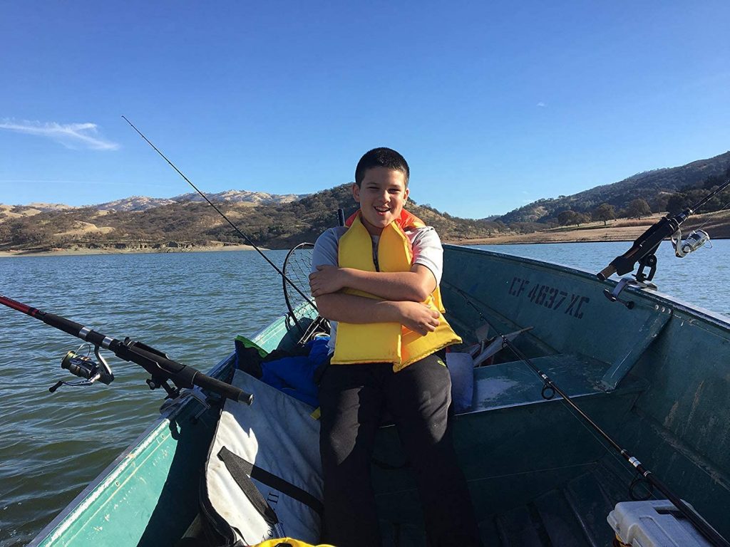 image of a boy on boat with fishing rod holder