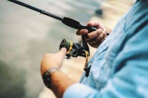 a man holding a fishing rod with reel