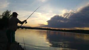 a man fishing in the dark