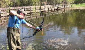 fisherman doing bowfishing